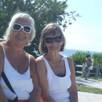 Two sisters smile in the sunshine wearing white tank tops in the Florida Keys