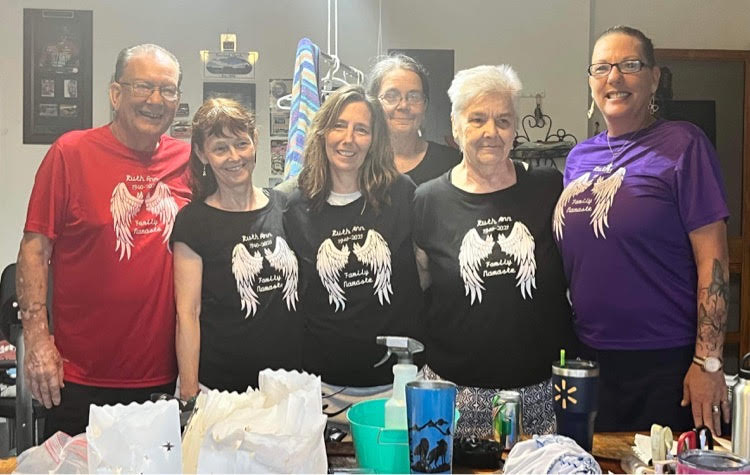 Memory t-shirts modeled by a family in a garage say Ruth Boschard Family Namaste